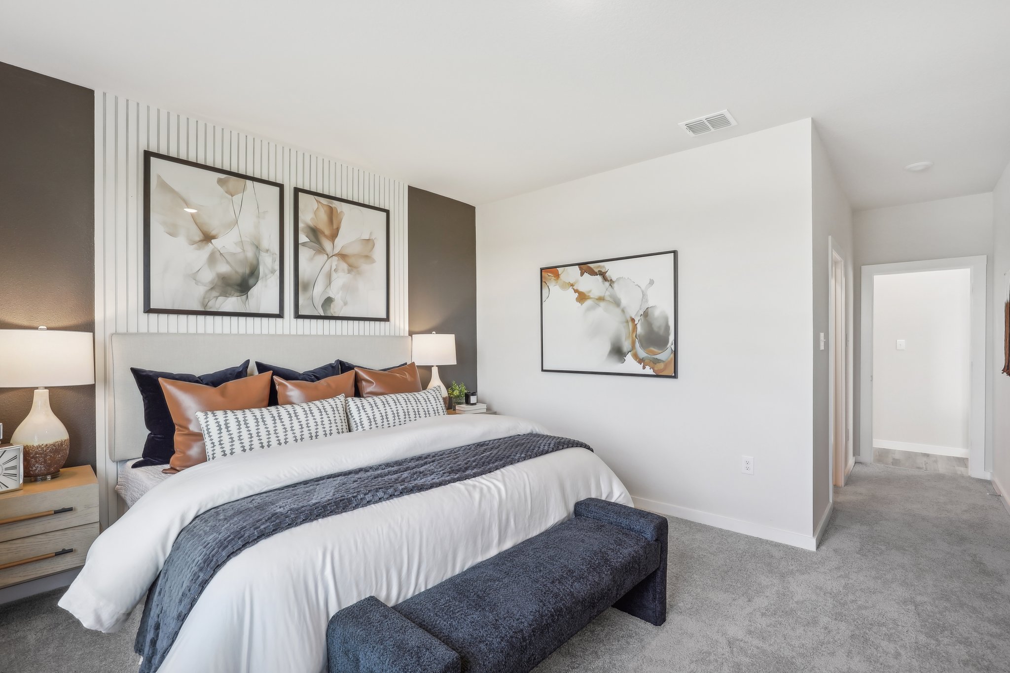 A bedroom with a bed and a bench.