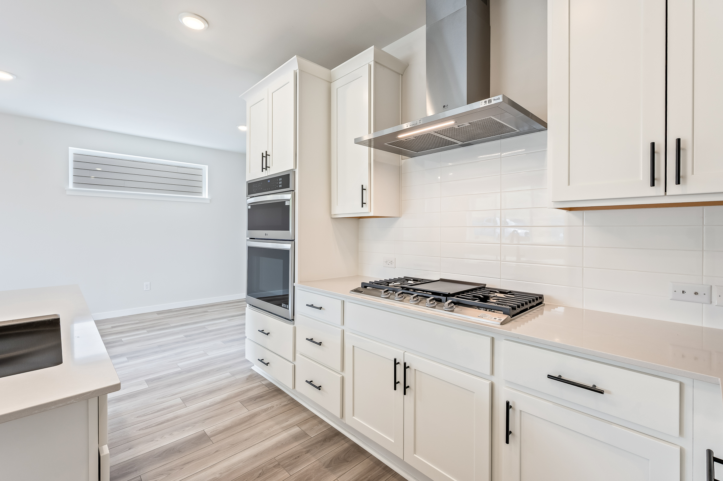 A kitchen with white cabinets.