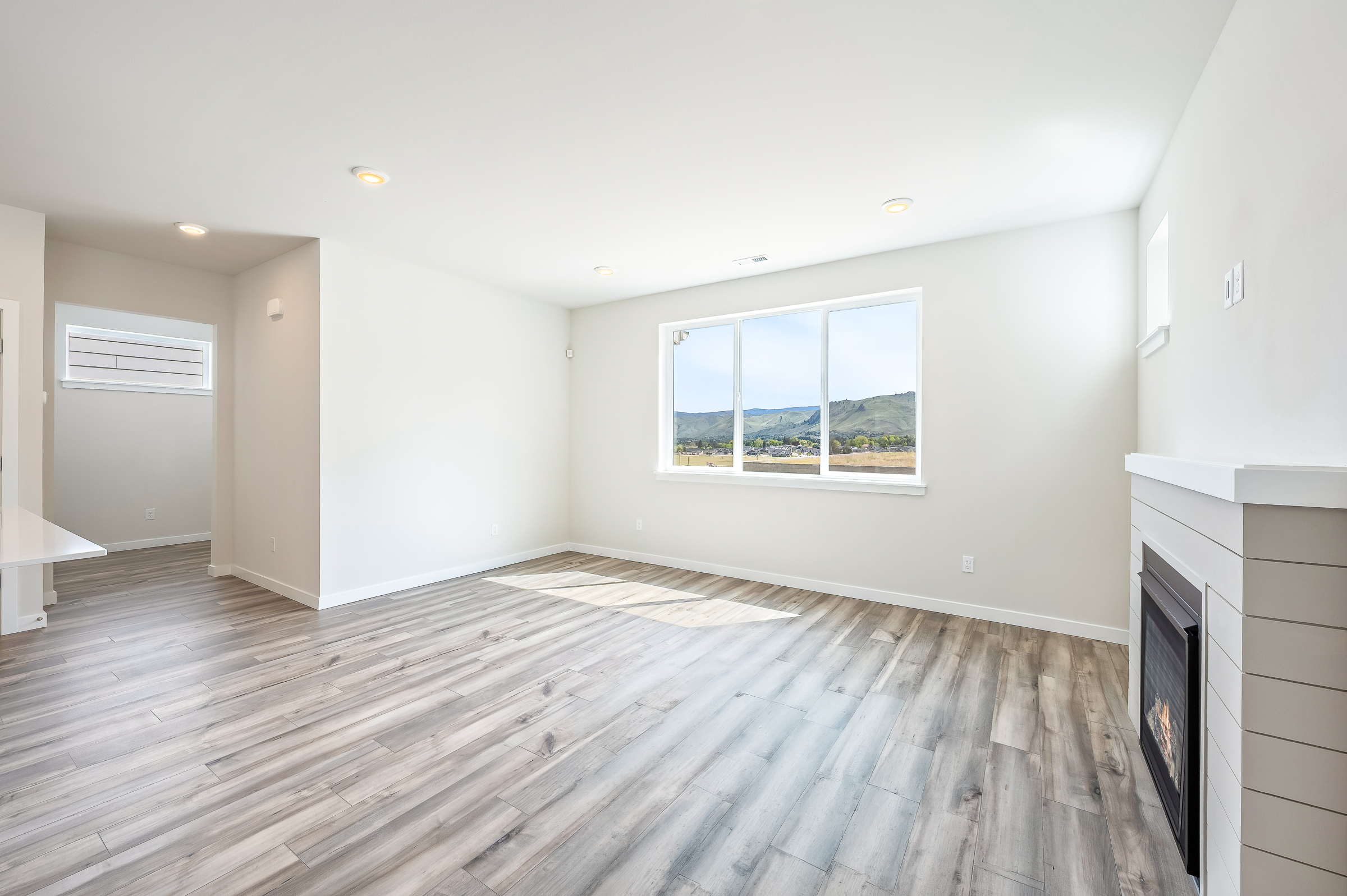 A room with a wood floor and a fireplace.