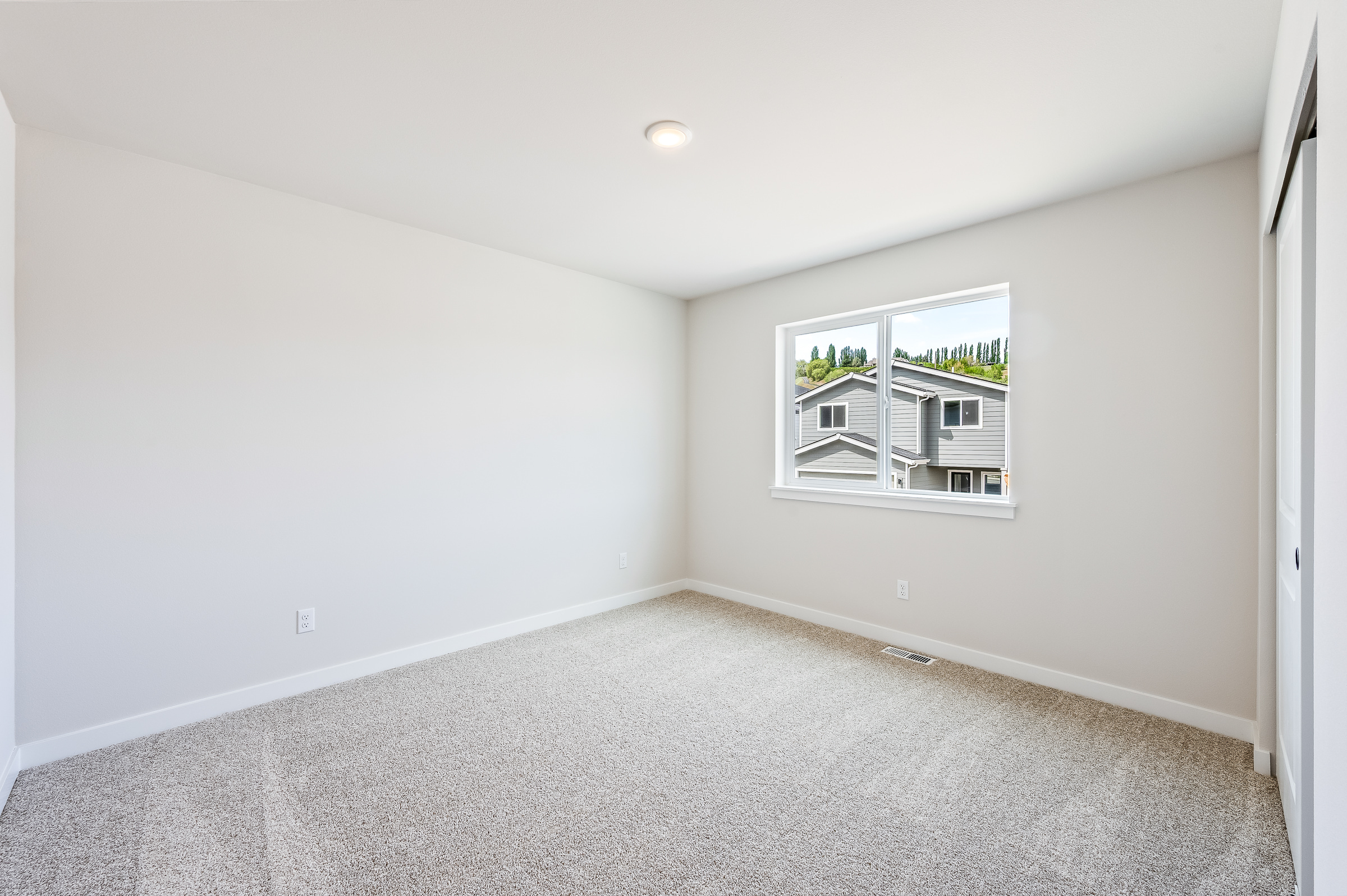 A room with a window and a carpet.