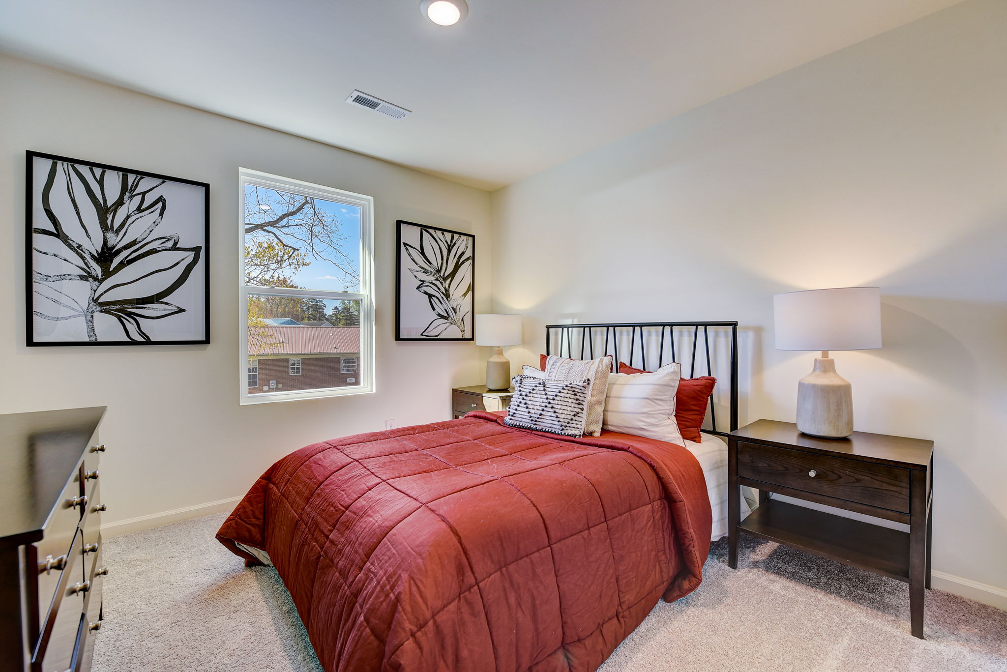 A bedroom with a bed and lamps.