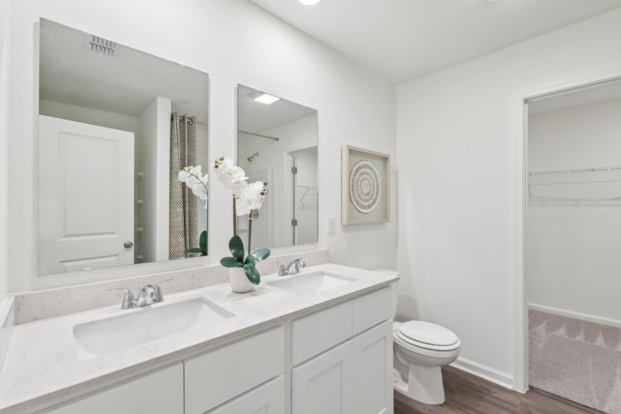 A bathroom with a sink toilet and mirror.