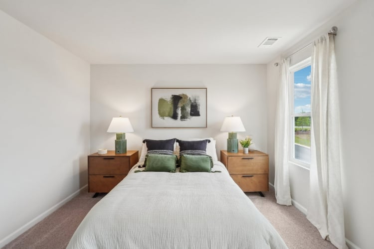 A bedroom with a bed and lamps.