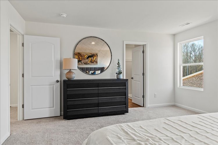 A bedroom with a large mirror.