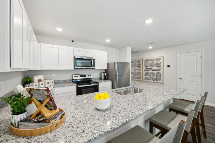 A kitchen with white cabinets.