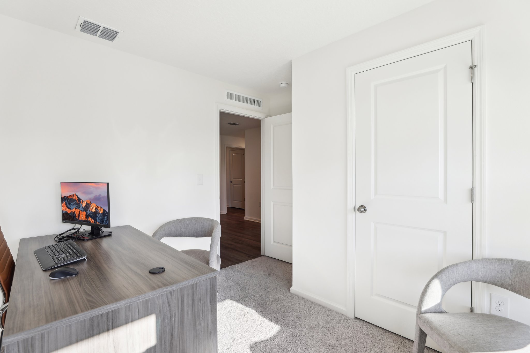 A room with a desk and a tv.