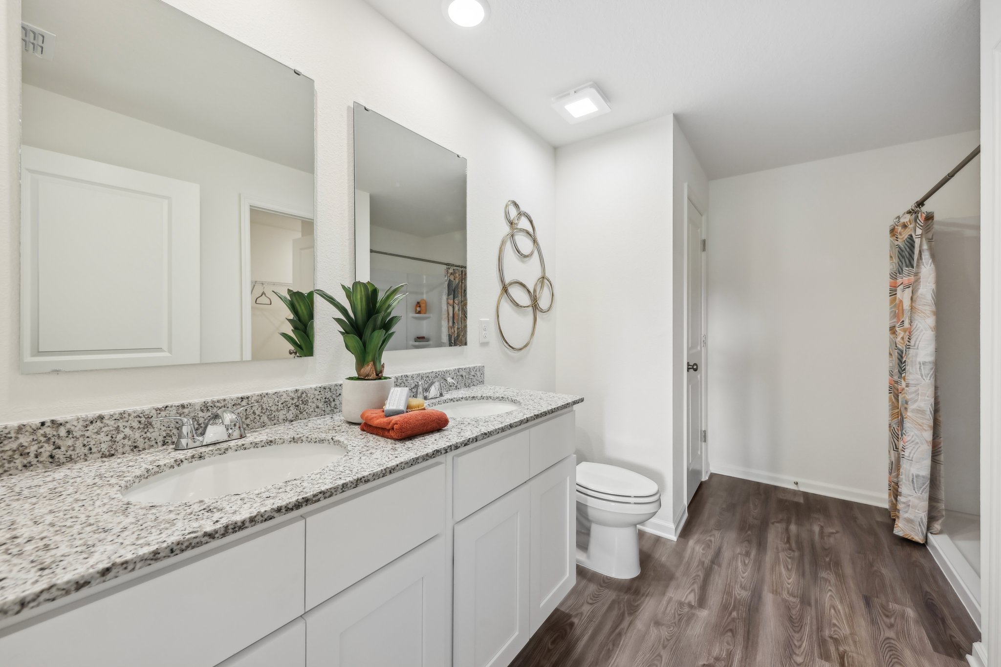 A bathroom with a sink toilet and mirror.
