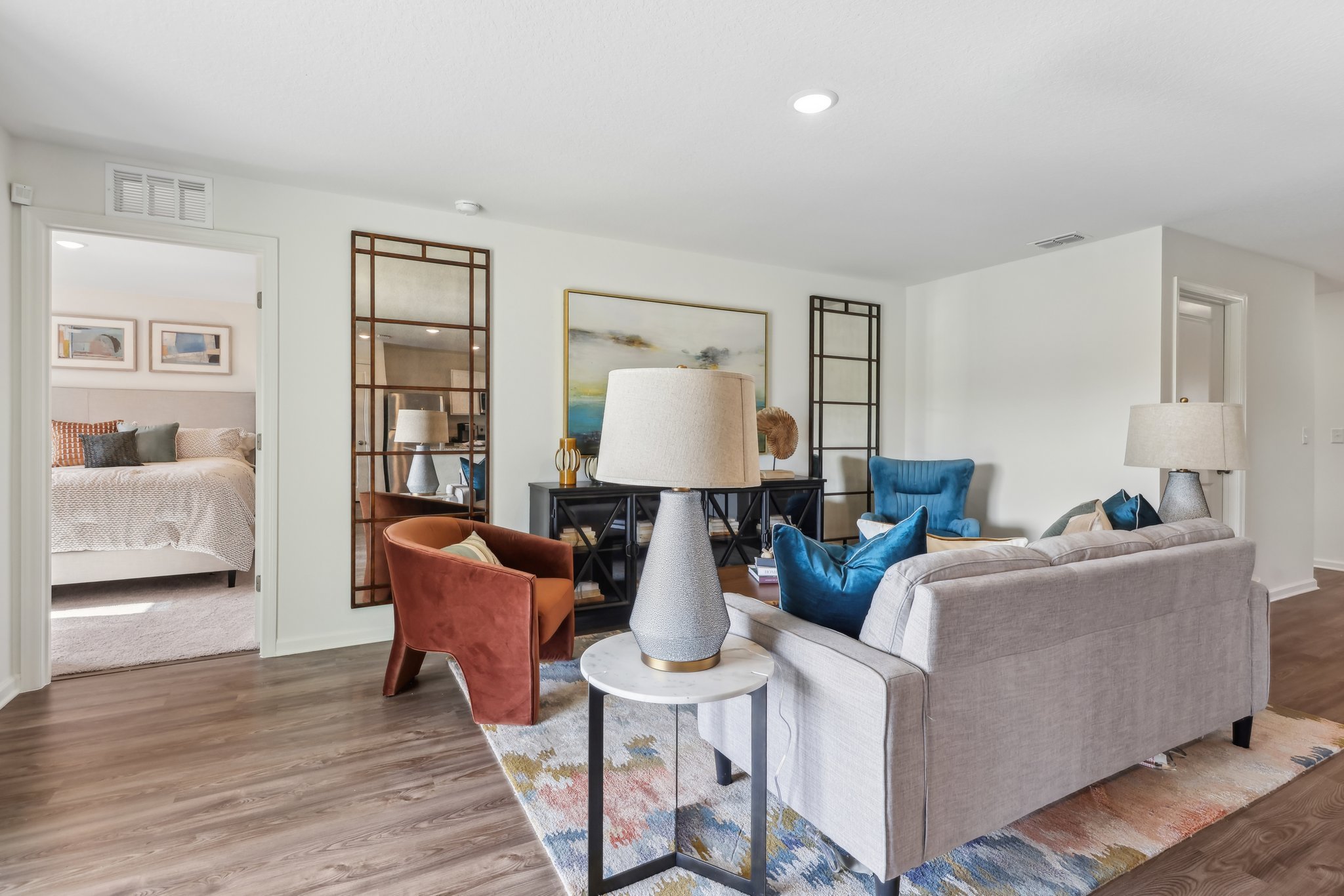 A living room with a bed and a lamp.