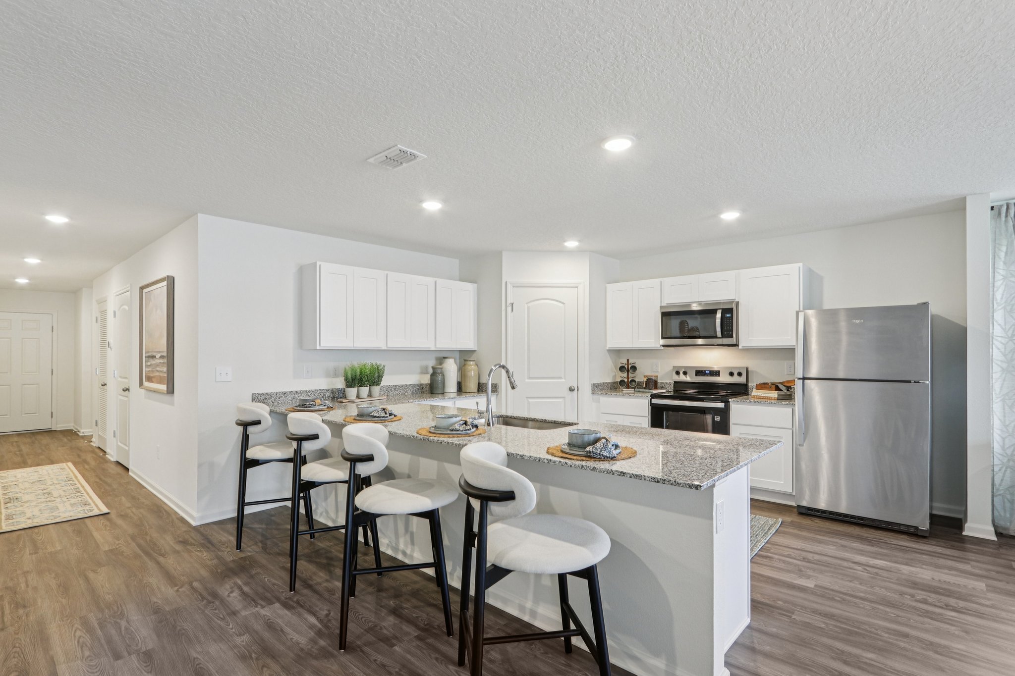 A kitchen with white cabinets.