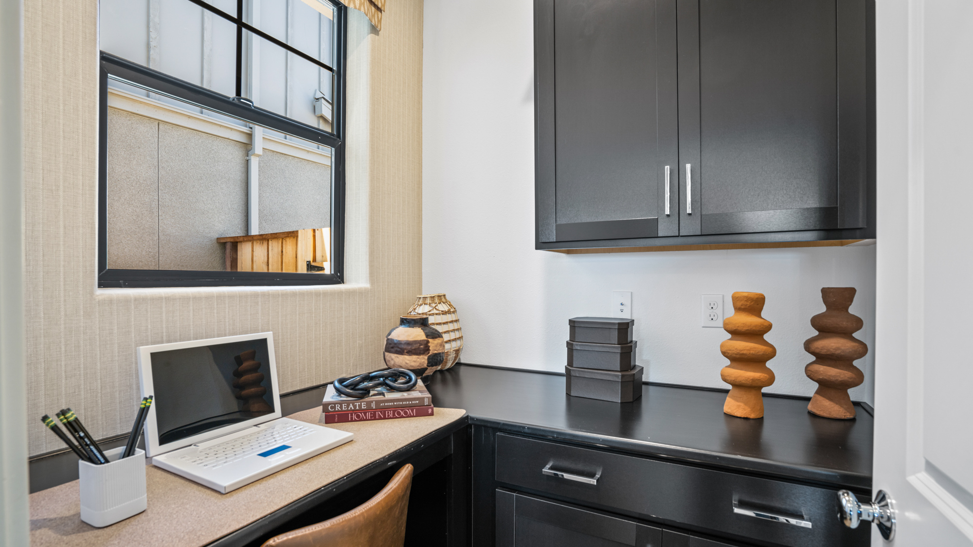 A kitchen with a laptop and a table.